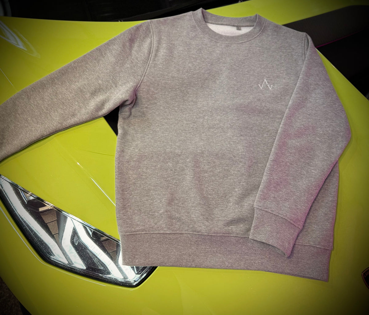Grey AV branded sweatshirt on the bonnet of a lime green Lamborghini Revuelto